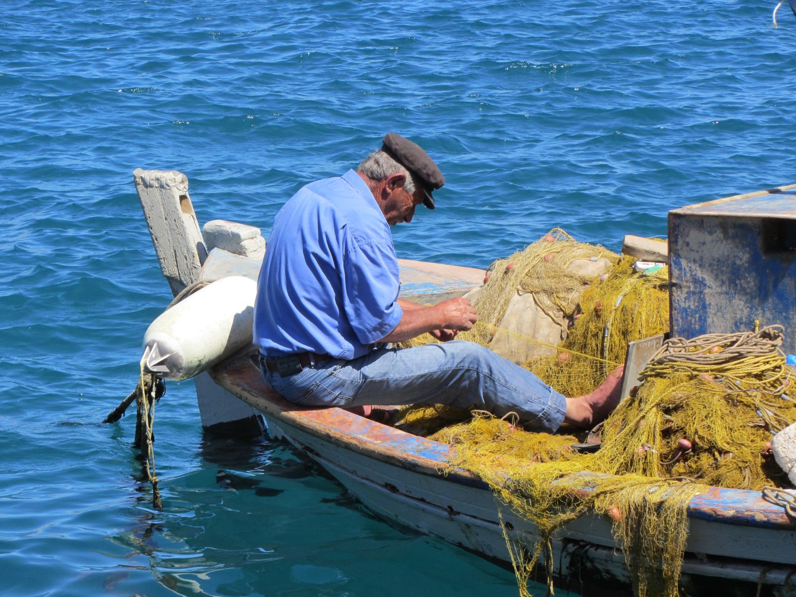 Fisherman repairing nets in the Greek islands