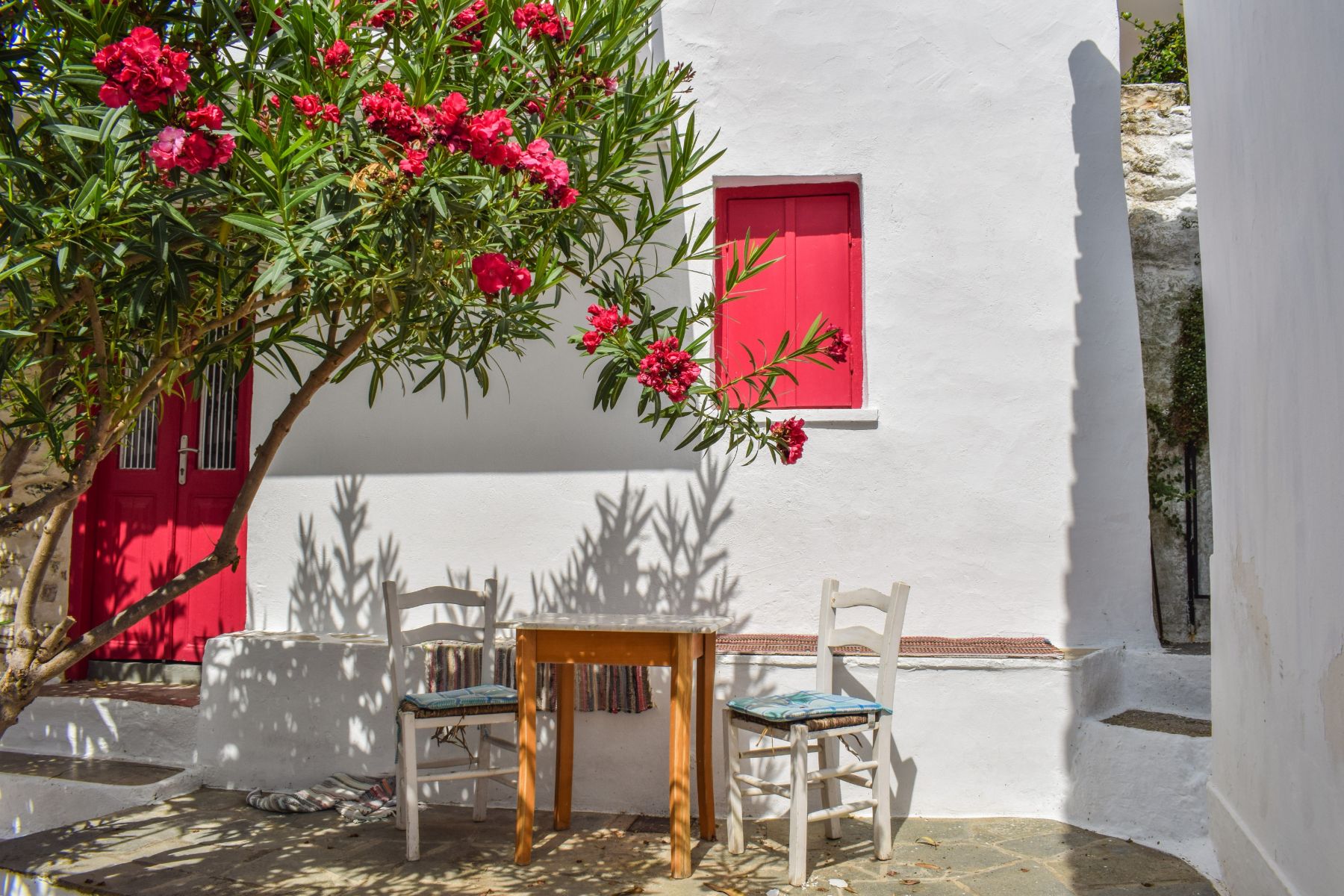 A courtyard in Greece with seating area and flowers