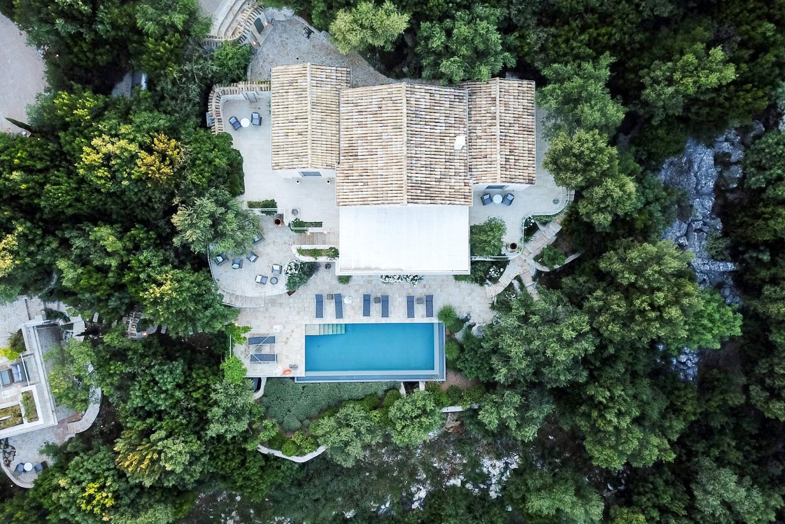 View of the roof and pool at villa apraos in corfu, Greece from above surrounded by trees