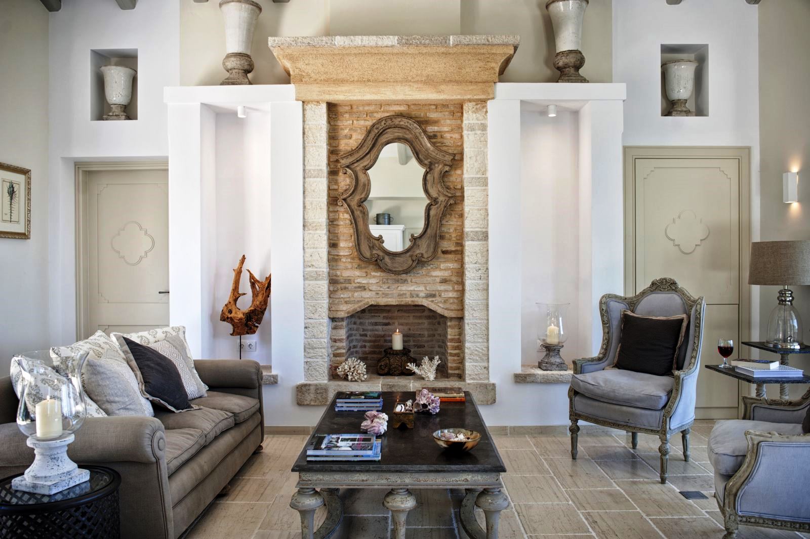 Living room with mirror over fireplace, sofa, chairs and coffee table at villa apraos in corfu, Greece