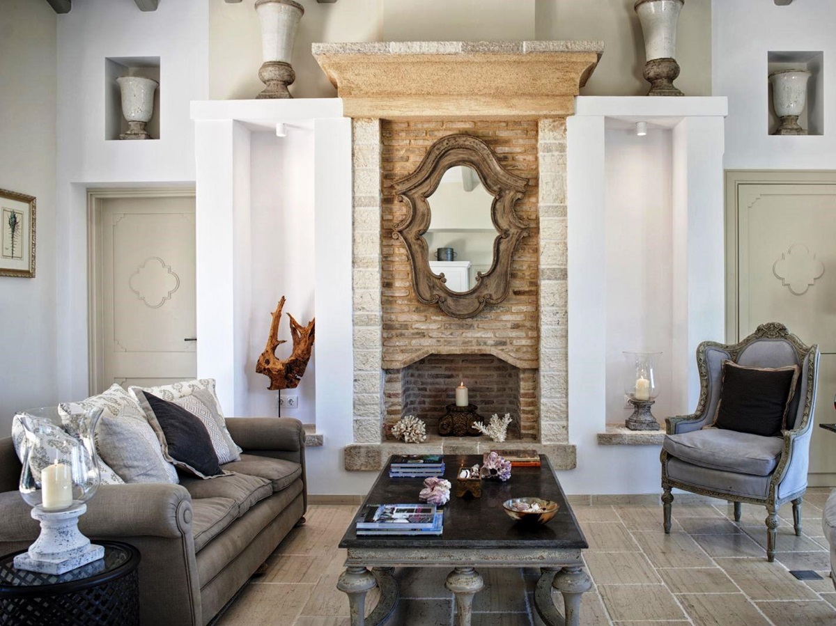 Living room with mirror over fireplace, sofa, chairs and coffee table at villa apraos in corfu, Greece