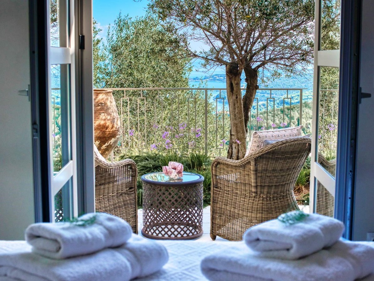 2 wicker chairs and round table on balcony overlooking the sea at villa apraos in corfu, Greece