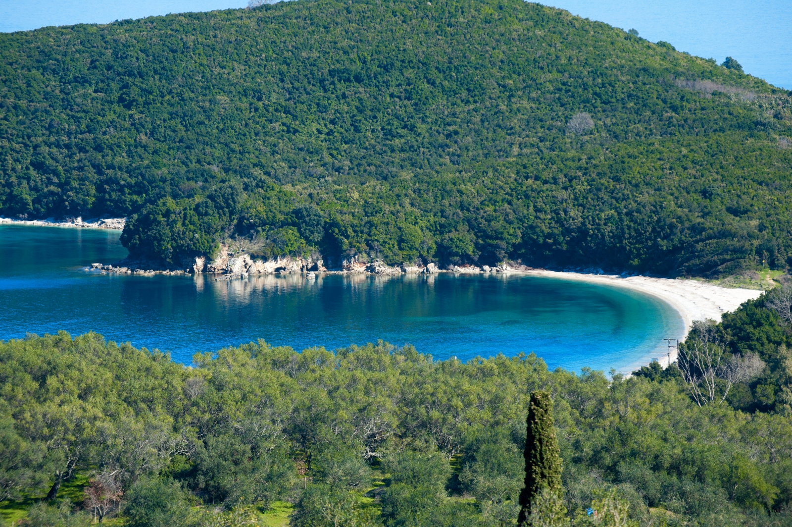 Cove near to Eremitis on Corfu, Greece with forest, white sand and crystal-clear water.