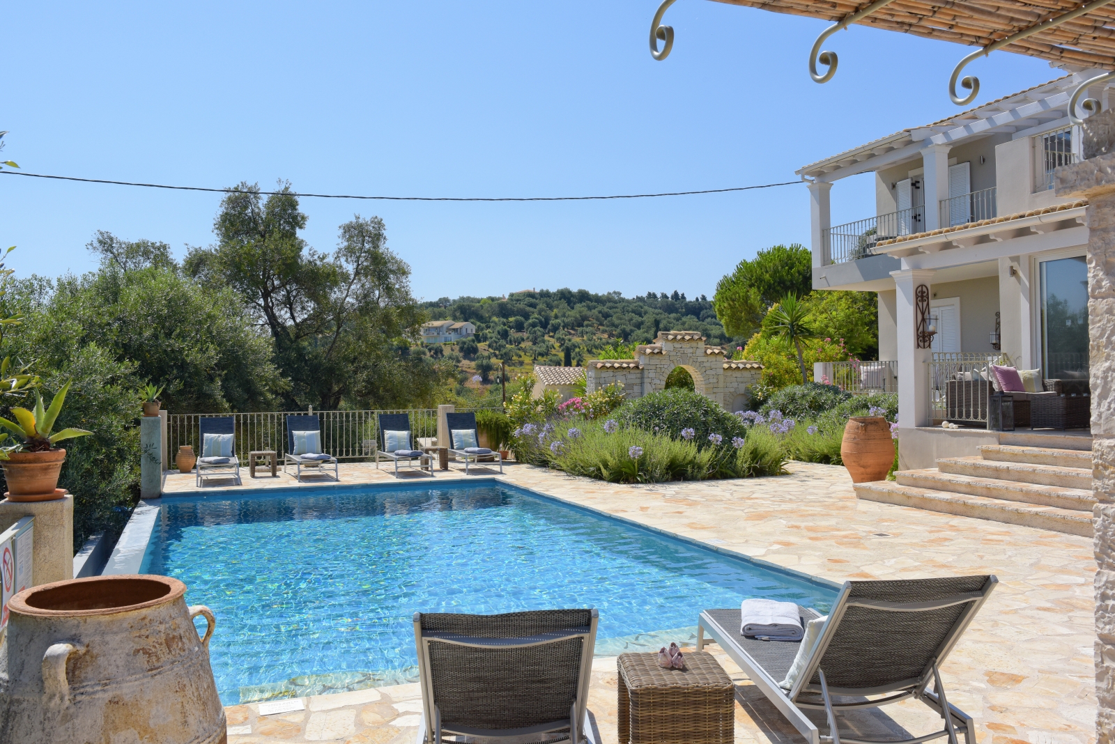 View of pool, patio and villa from covered outdoor dining area at Eremitis on Corfu, Greece