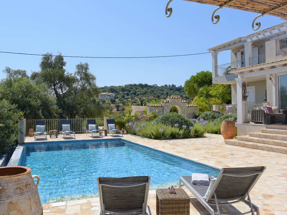 View of pool, patio and villa from covered outdoor dining area at Eremitis on Corfu, Greece