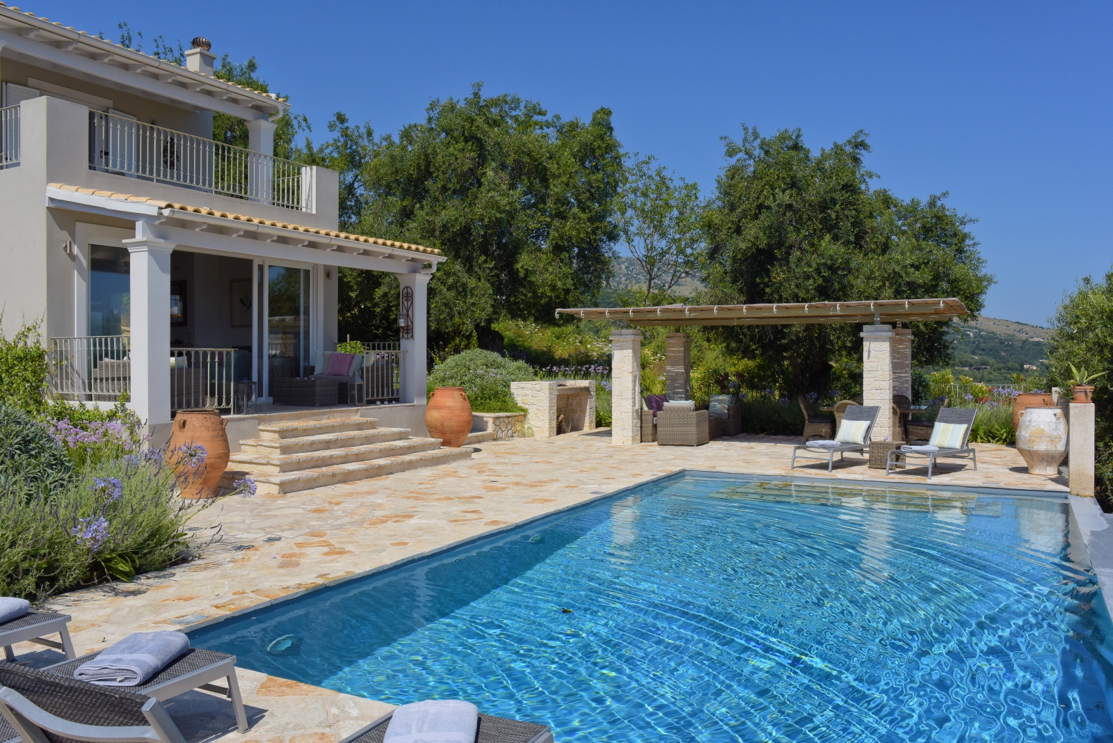 Pool, patio, covered dining area and villa at Eremitis on Corfu, Greece