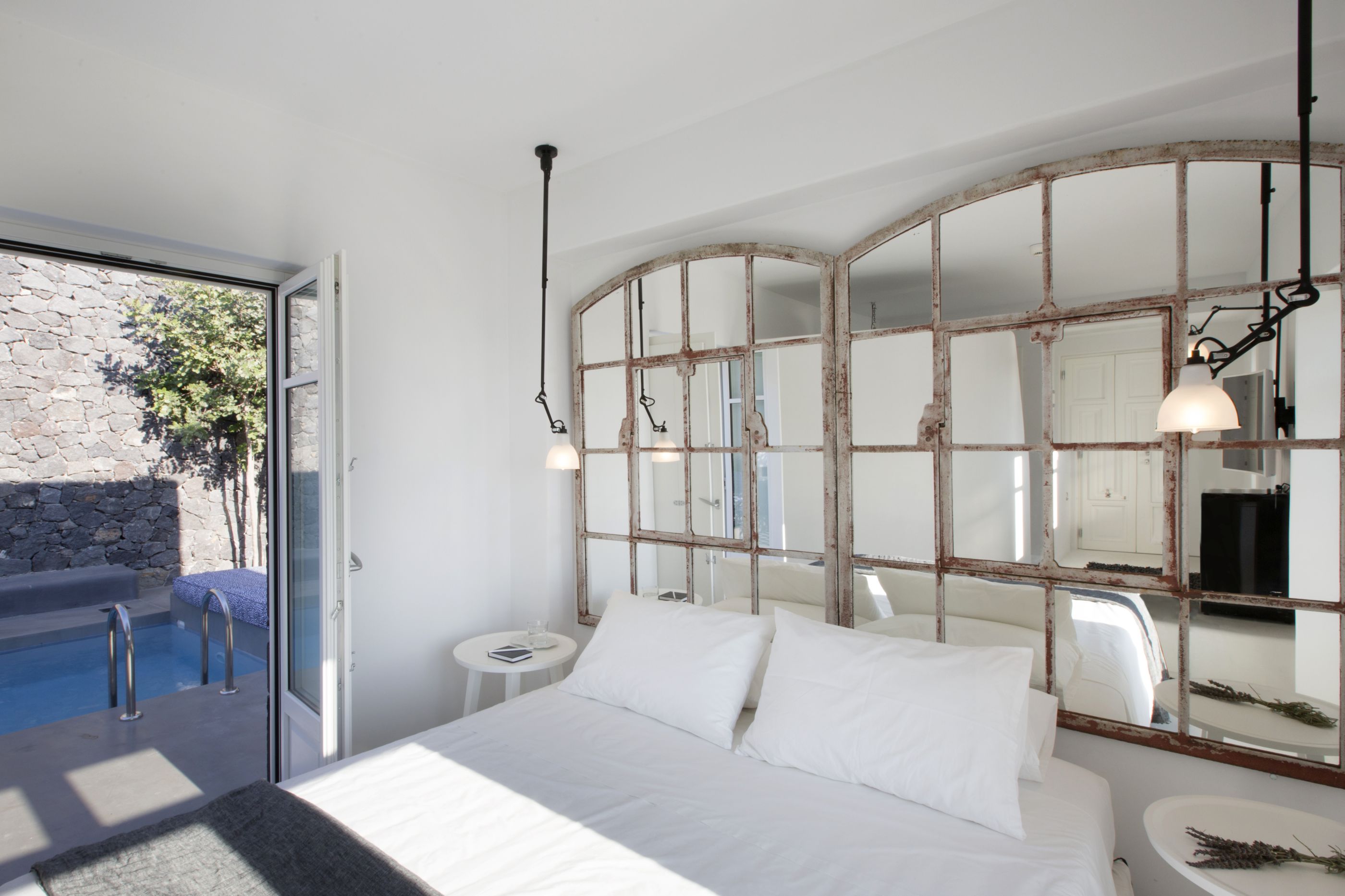 Double bedroom with mirror and swimming pool access of Erosantorini, Greece