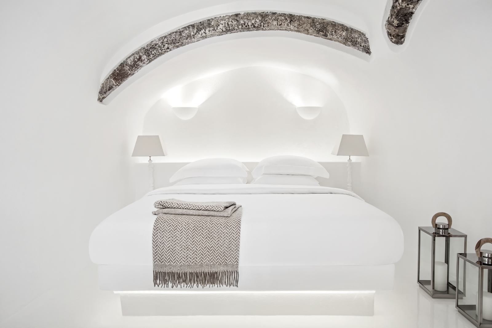 Bedroom with double bed, lamps and lanterns at Erossea on Santorini, Greece