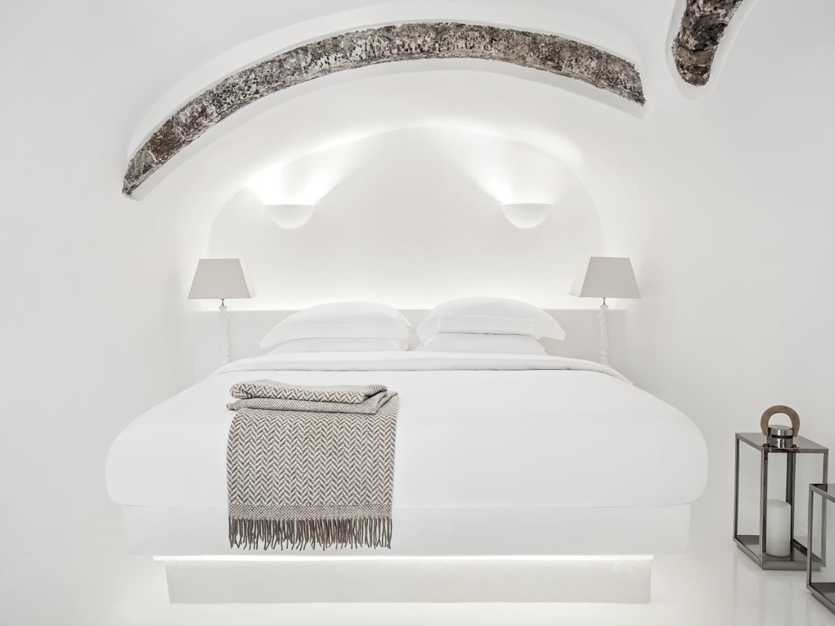 Bedroom with double bed, lamps and lanterns at Erossea on Santorini, Greece
