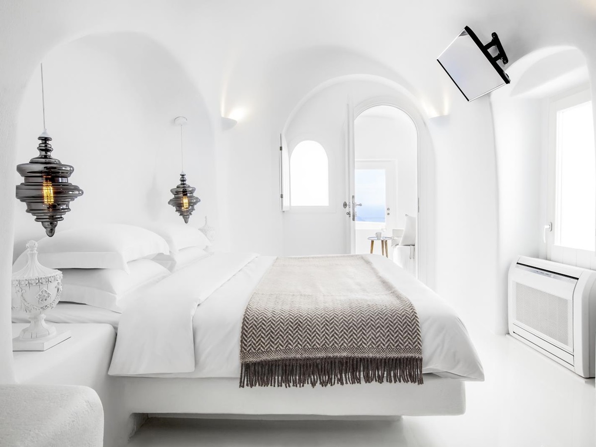 Bedroom with double bed, lamps & hanging lights at Erossea on Santorini, Greece
