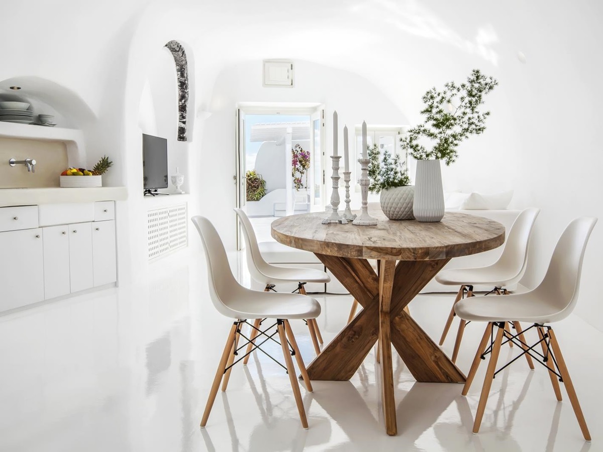 Kitchen with table, chairs, plants, candles and sink at Erossea on Santorini, Greece