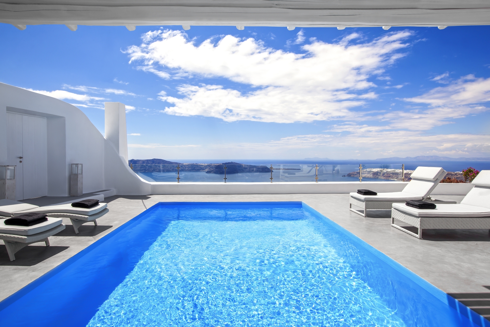 Pool and pool area with sun loungers and sea view at Erossea on Santorini, Greece