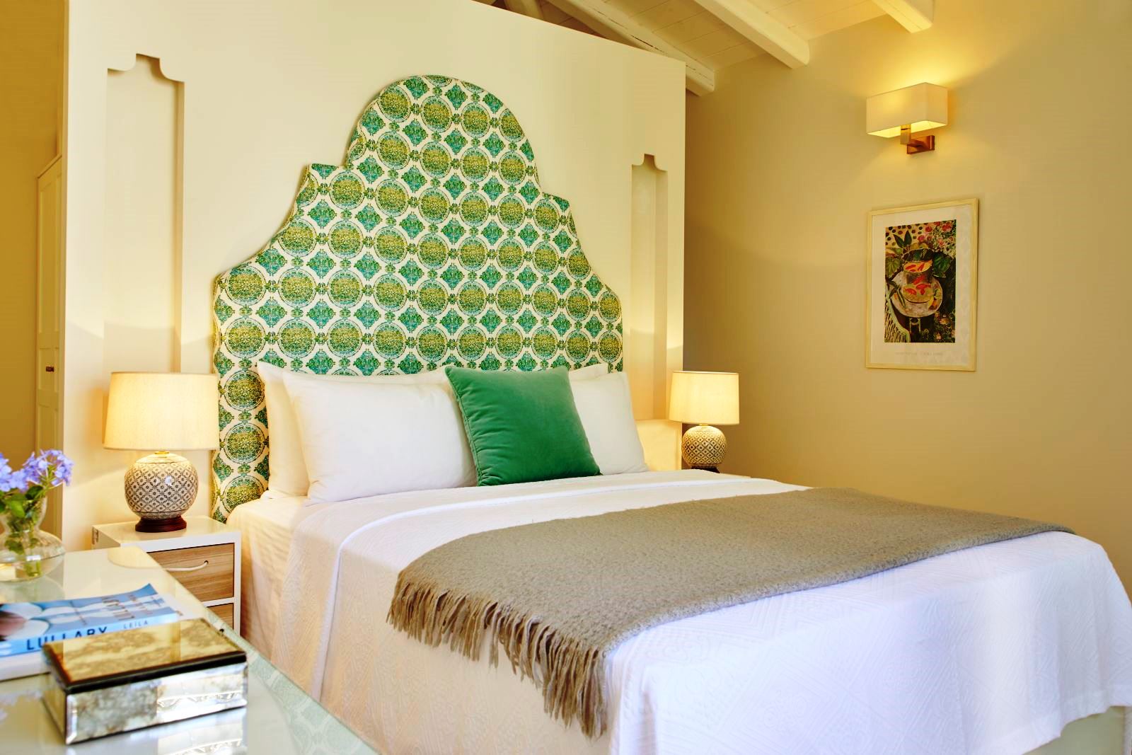 double bed with green patterned headboard at kogevina beach villa in corfu, greece