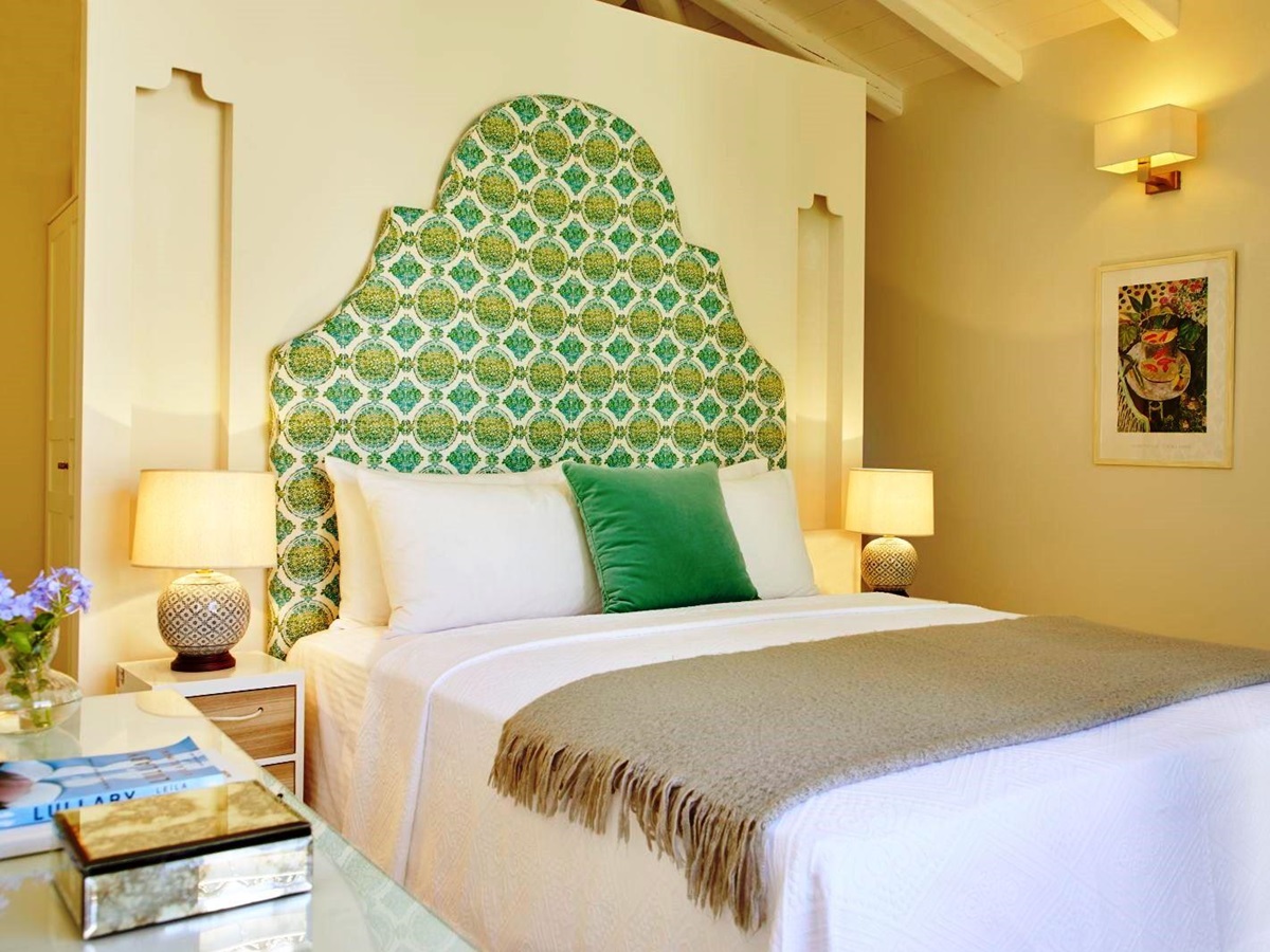 double bed with green patterned headboard at kogevina beach villa in corfu, greece
