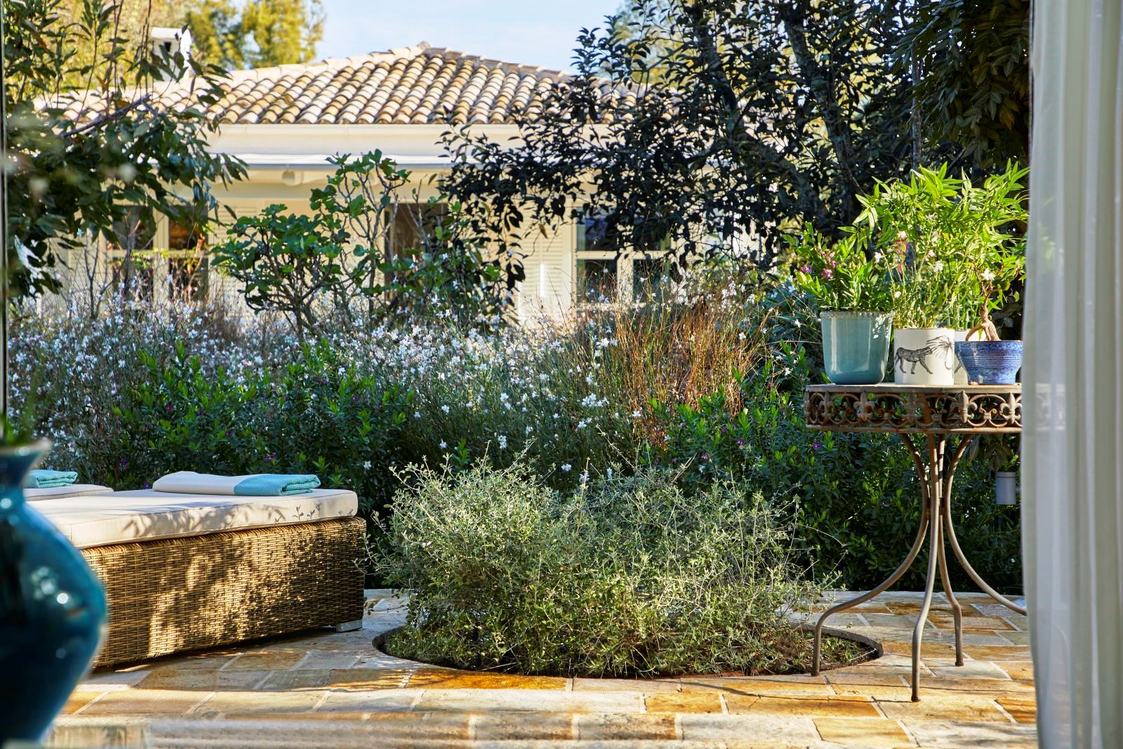garden with stone terrace at kogevina beach villa in corfu, greece