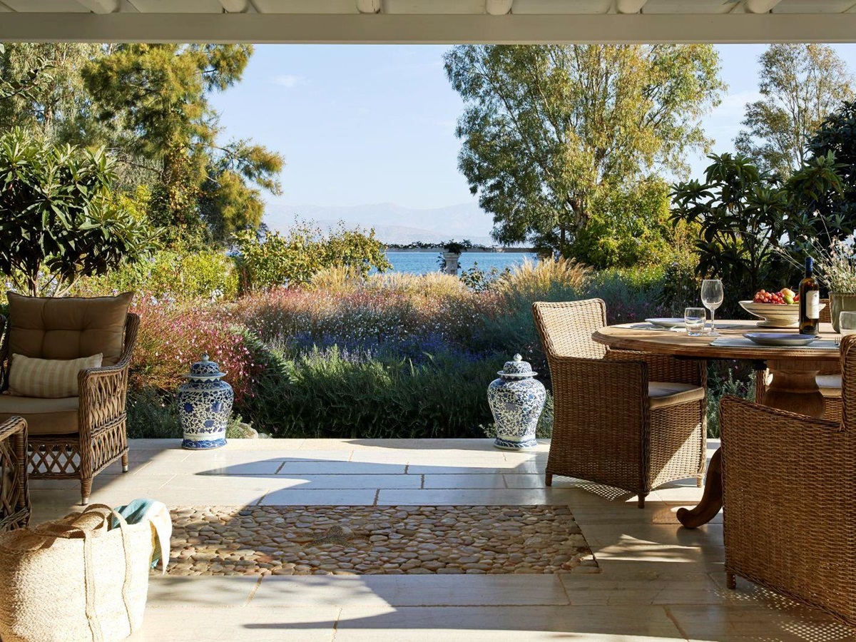 two wicker chairs and round table on the terrace at kogevina beach villa in corfu, greece