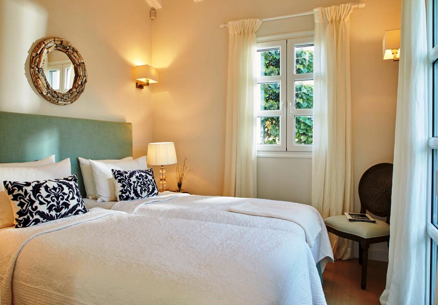 twin beds with white bedspreads and blue pillows at kogevina beach villa in corfu, greece