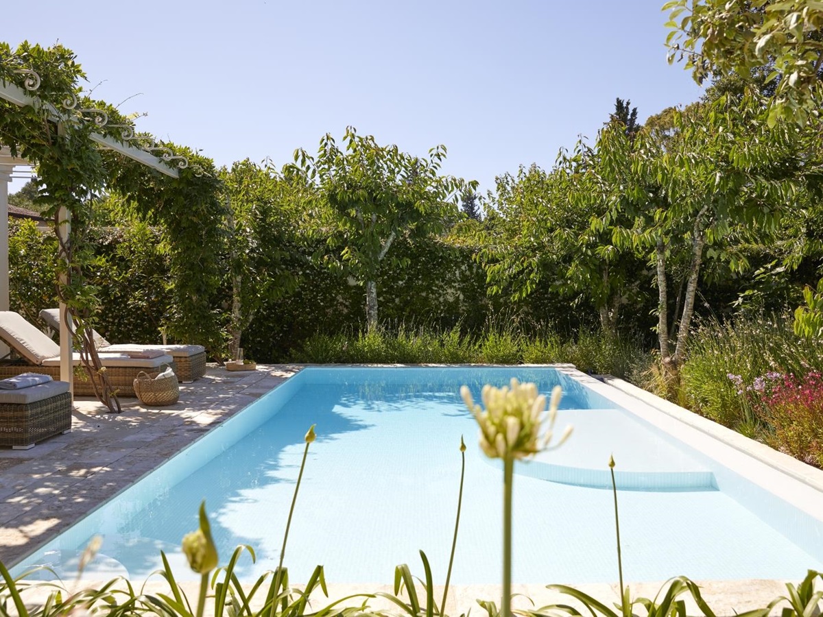 Pool and pool area with sun loungers and flowers at Kogevina Beach Villa on Corfu, Greece