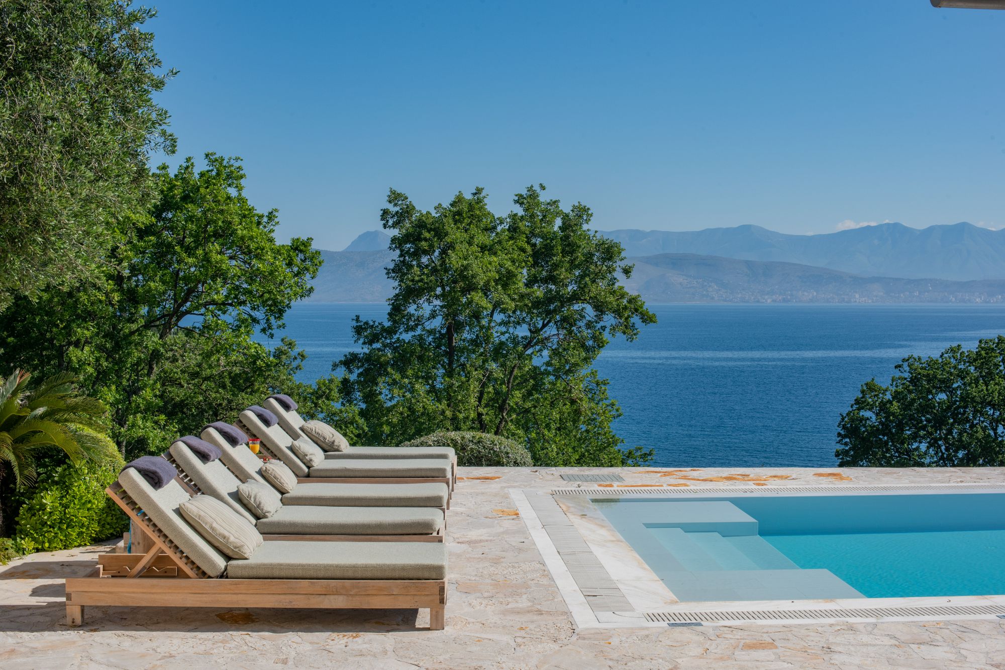 Pool with sun loungers at Villa Anthi