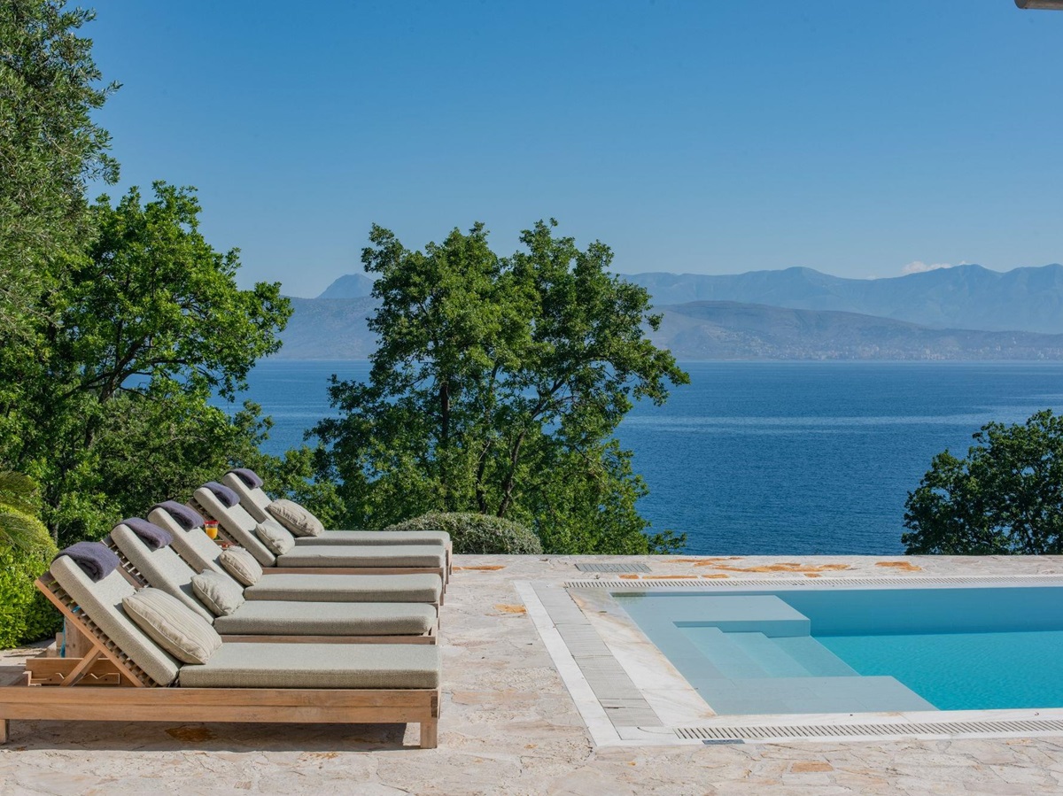 Pool with sun loungers at Villa Anthi
