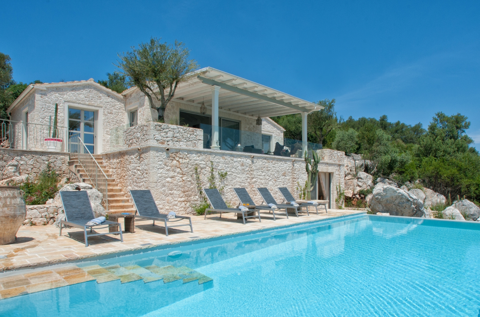 Exterior of villa with pool and loungers at Villa Dionysos, Corfu