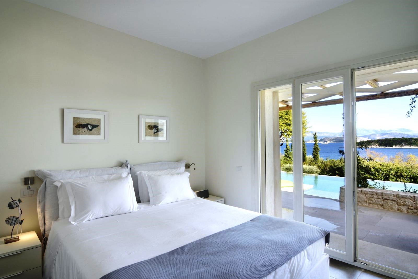 Double bedroom with patio doors with views over the pool at villa eleni in corfu, Greece