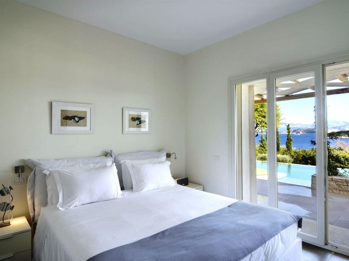 Double bedroom with patio doors with views over the pool at villa eleni in corfu, Greece