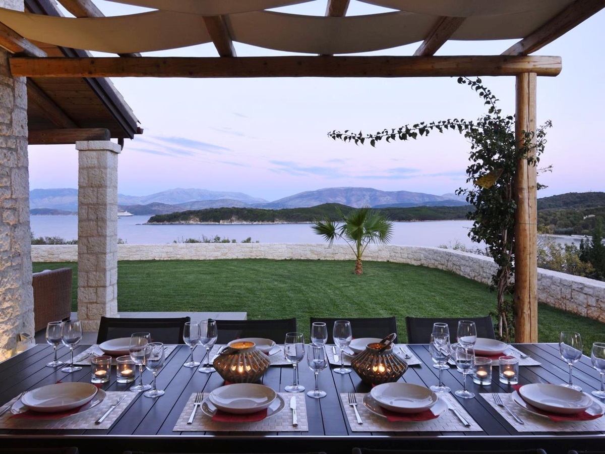 Dining table set for dinner on an outdoor terrace overlooking the sea at villa eleni in corfu, Greece