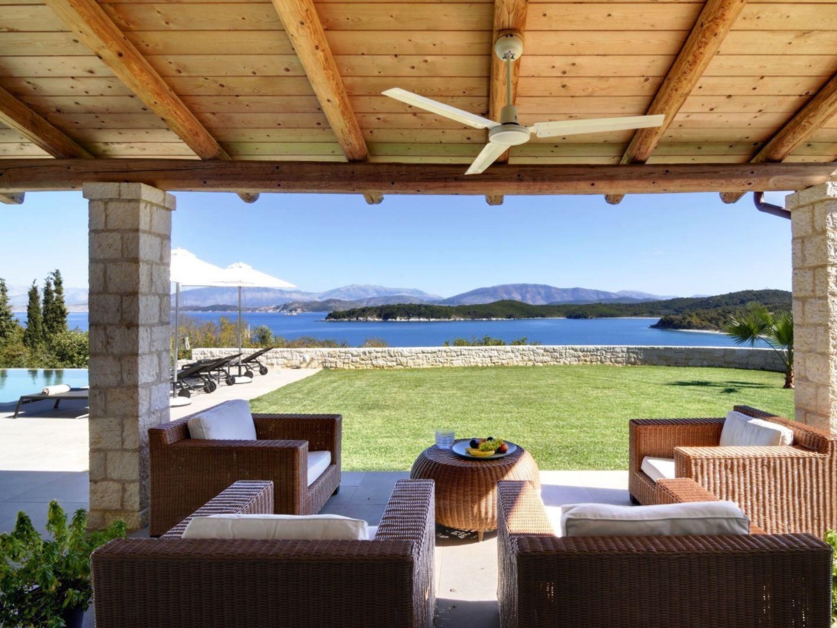 4 comfy wicker chairs with white cushions under a wooden roof with ceiling fan at villa eleni in corfu, Greece