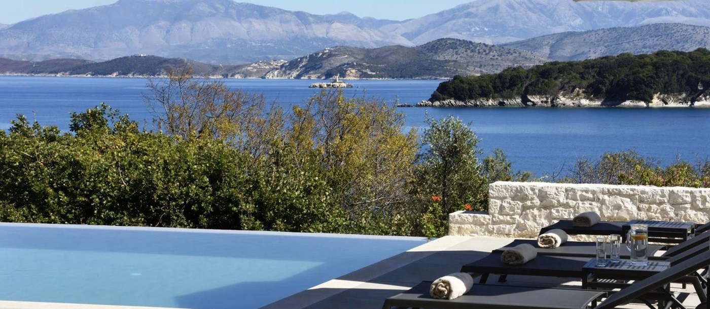 View over the pool with the sea and hills in the background at villa eleni in corfu, Greece
