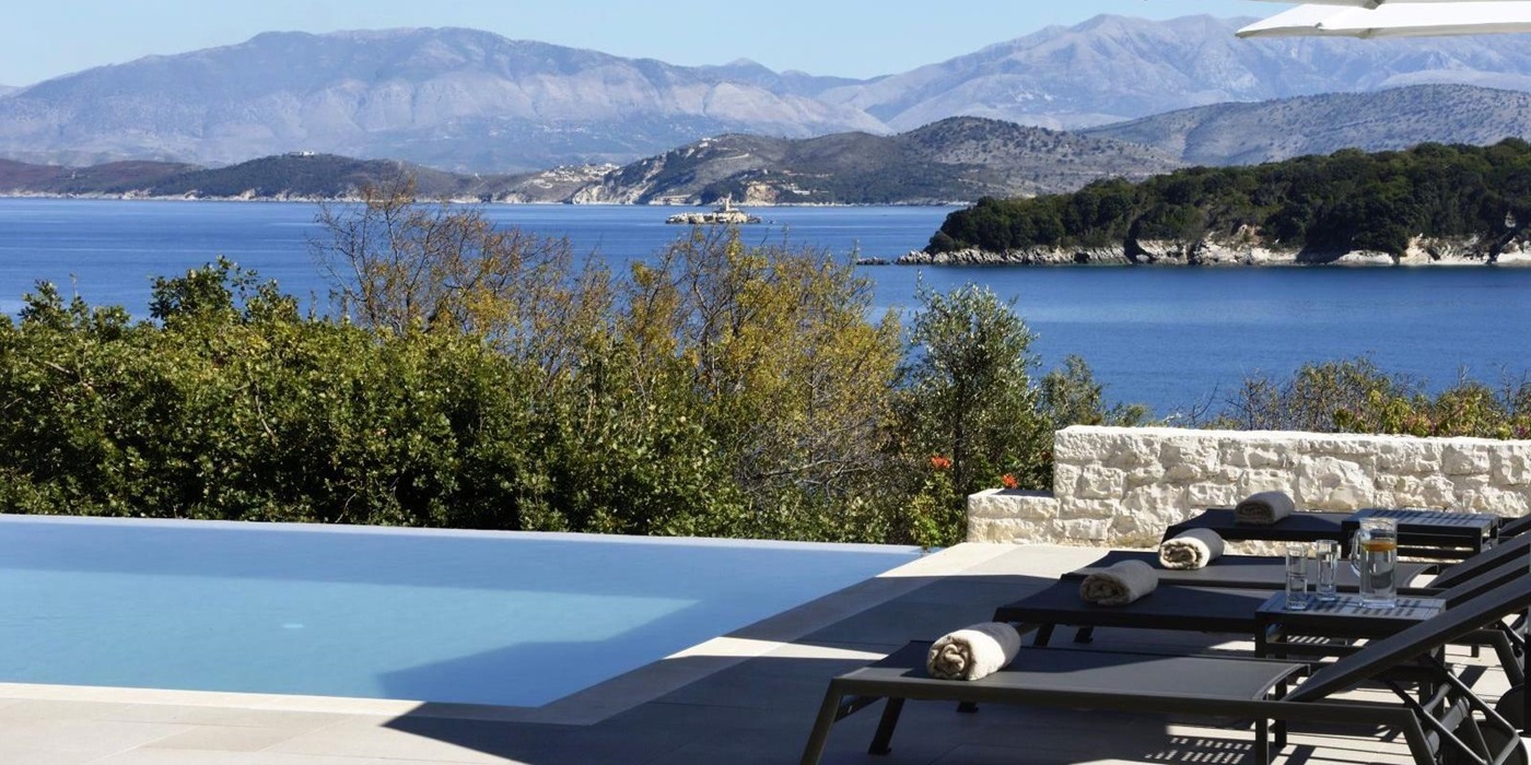 View over the pool with the sea and hills in the background at villa eleni in corfu, Greece