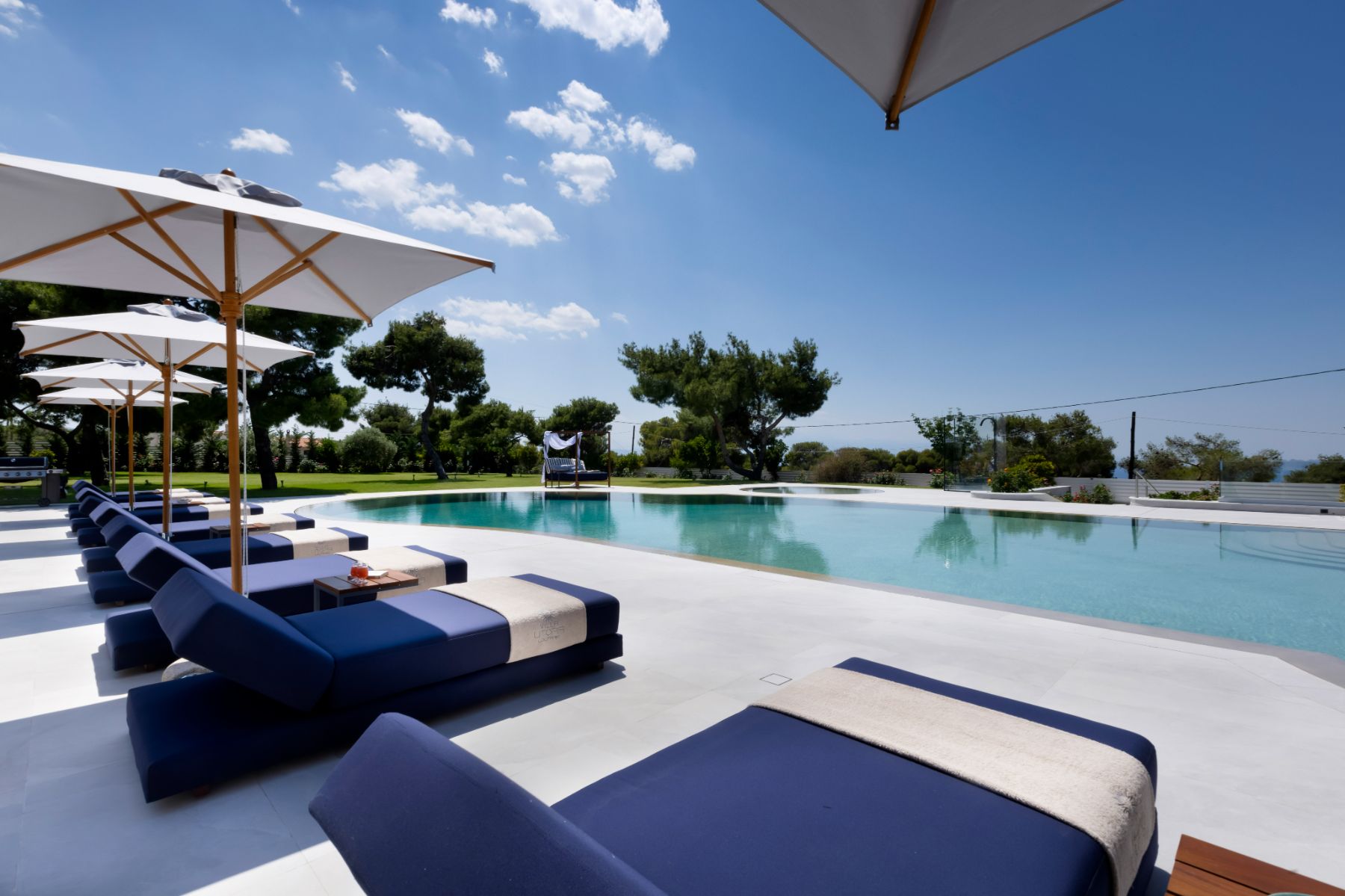 Pool with sun loungers at Villa Elysian