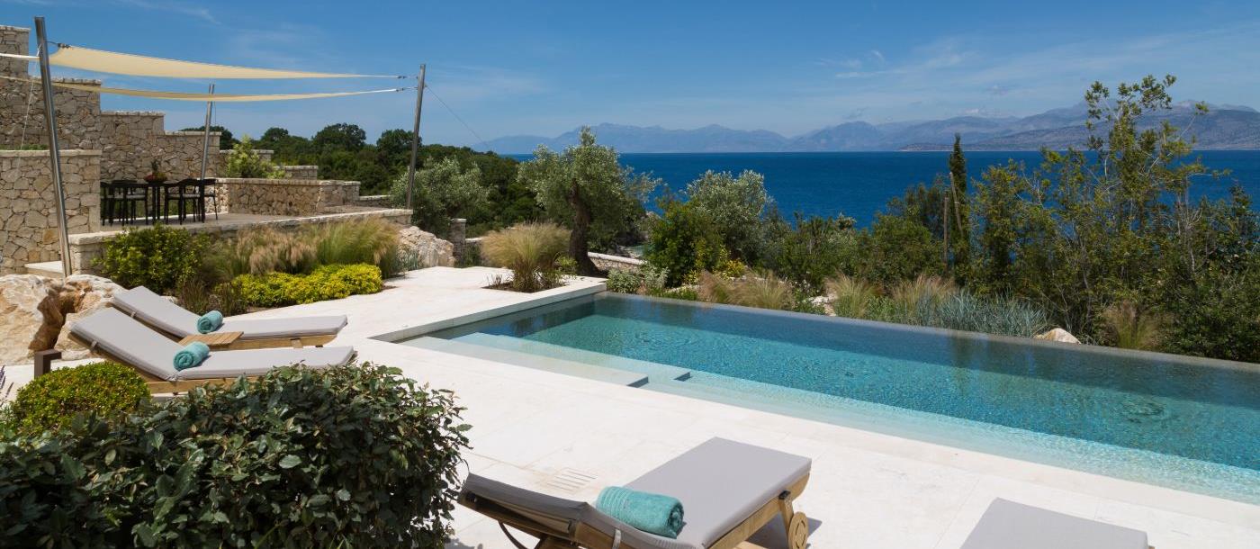Pool with loungers surrounded by gardens and views of the sea at Villa Epirus