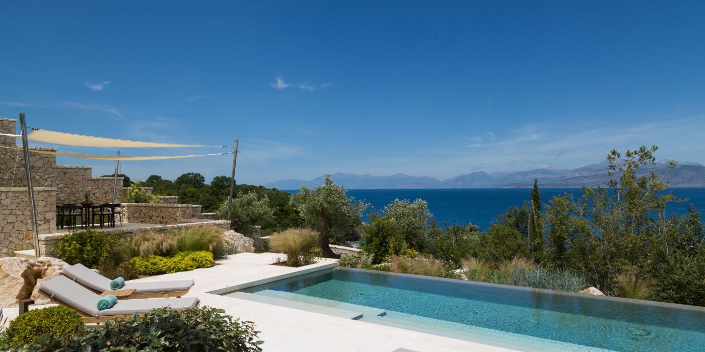 Pool with loungers surrounded by gardens and views of the sea at Villa Epirus