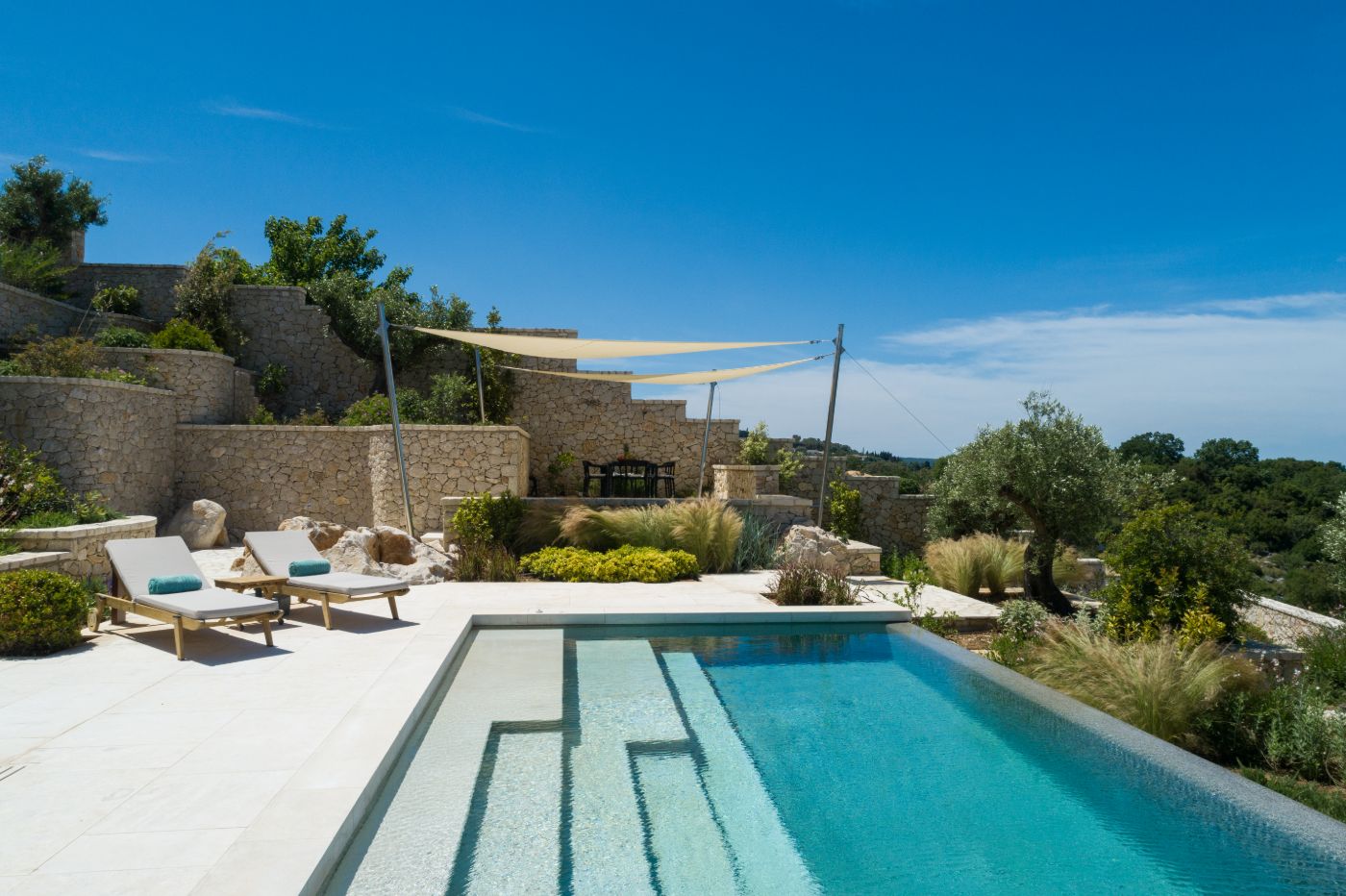 View of pool with terrace and gardens at Villa Epirus
