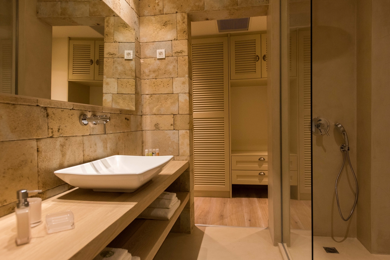 Bathroom with sink, large mirror, shower and cupboards at Villa Ianira on Crete, Greece