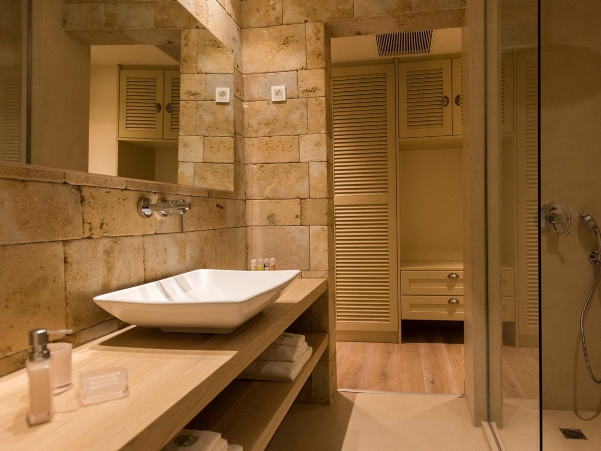 Bathroom with sink, large mirror, shower and cupboards at Villa Ianira on Crete, Greece