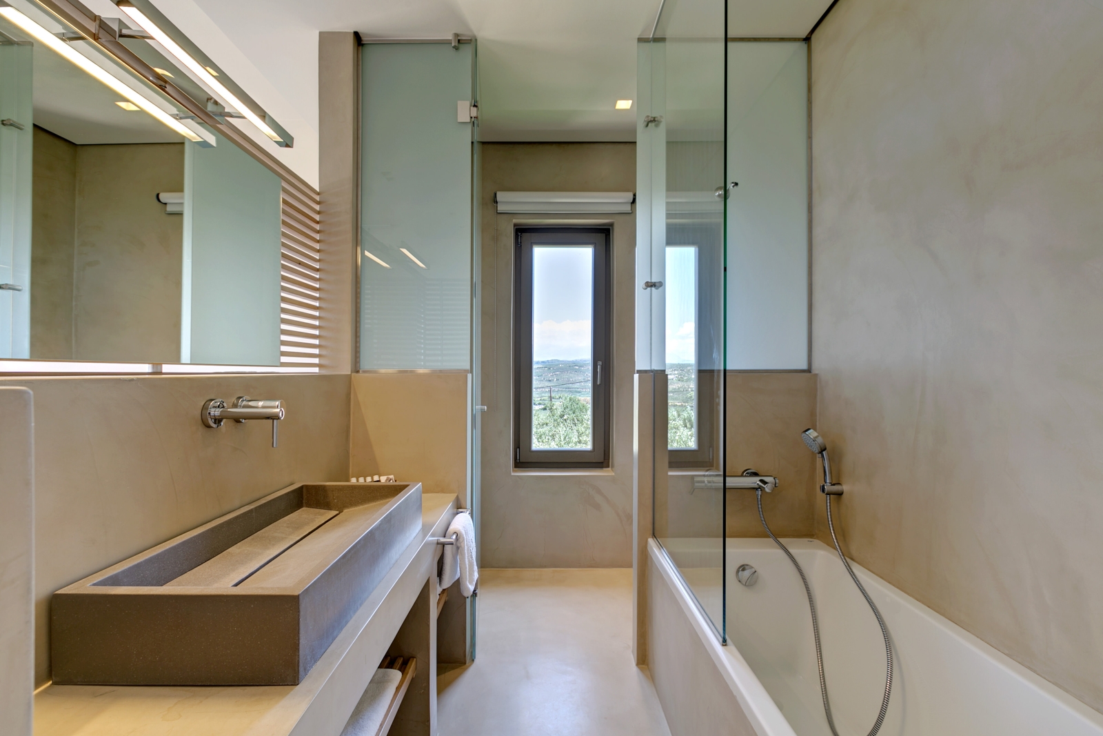 Bathroom with long sink, long mirror, bath and long window at Villa Ianira on Crete, Greece