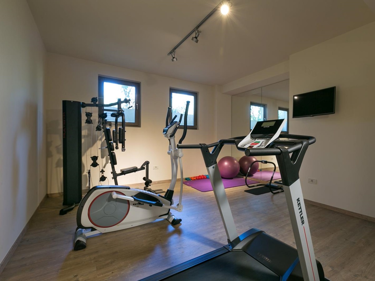 Gym with equipment, large mirrors and two small windows at Villa Ianira on Crete, Greece
