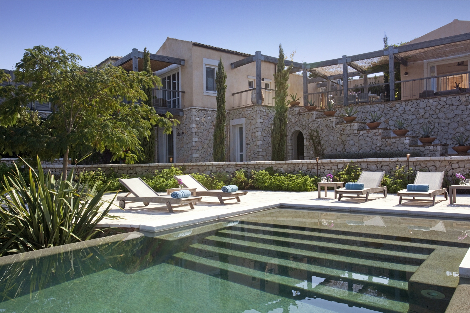 Pool, sun loungers and view of terrace at Villa Icarius on Corfu, Greece
