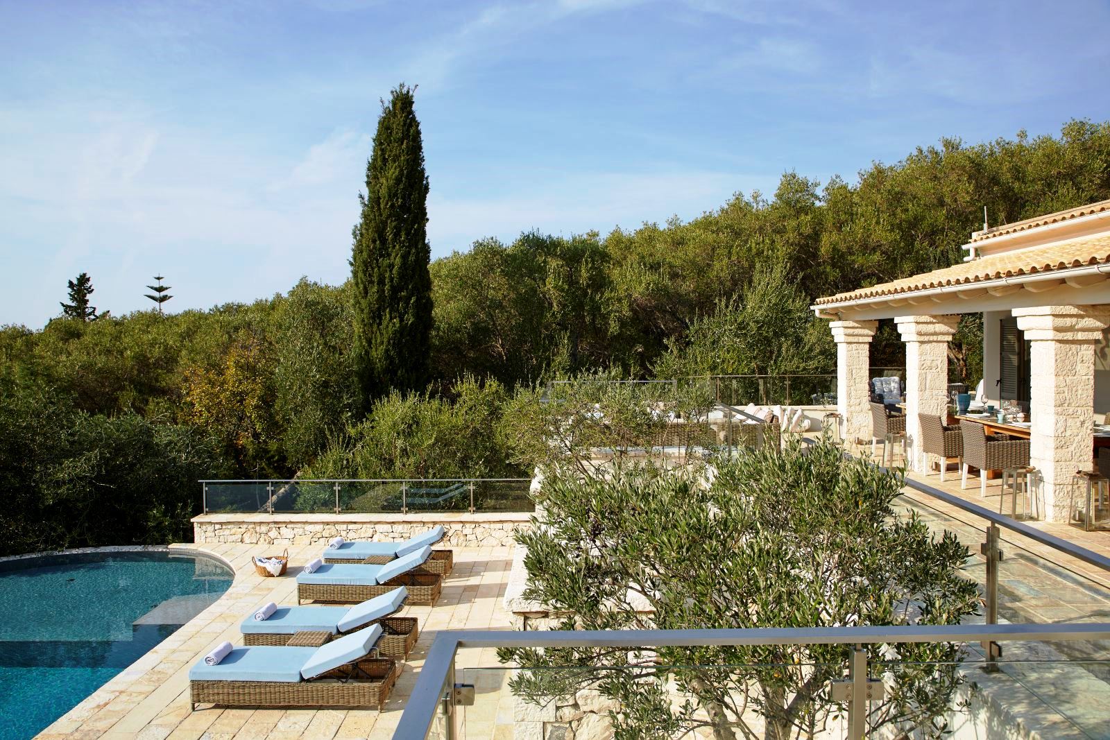 four blue sunloungers at the edge of the pool at villa castro on Corfu