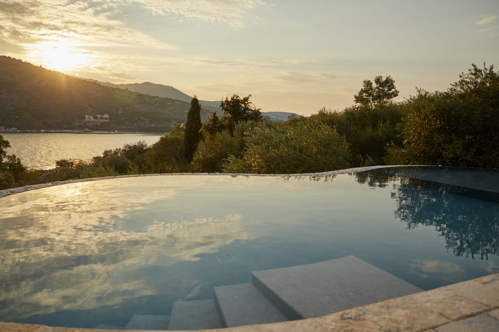 view over the pool with hills in the background at sunset at villa castro on Corfu