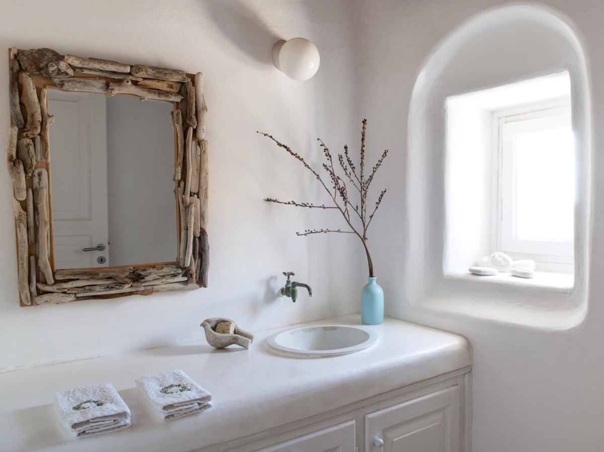 Bathroom with mirror, sink, towels, plant and windows at Villa Mari on Mykonos, Greece