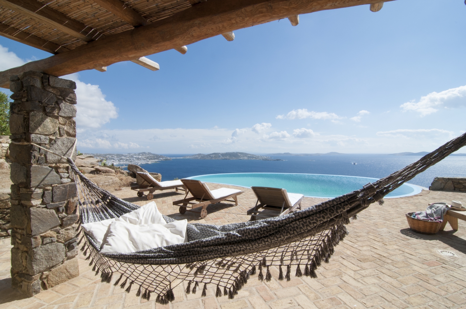 Hammock and terrace with sun loungers, infinity pool and sea view at Villa Mari on Mykonos, Greece