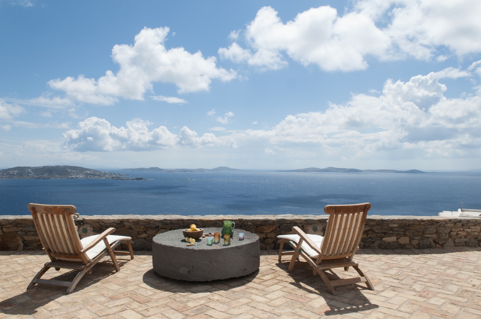 Terrace with sun loungers, table and sea view at Villa Mari on Mykonos, Greece