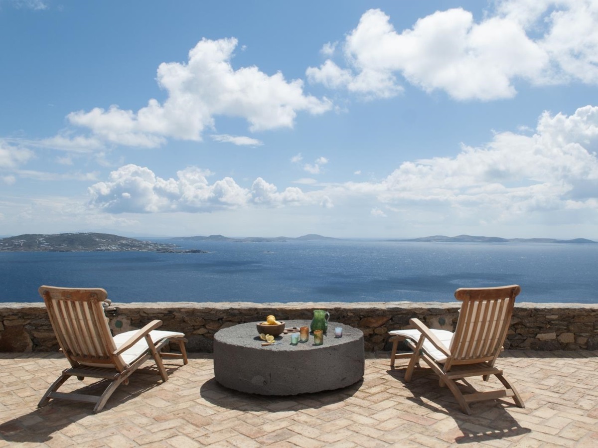 Terrace with sun loungers, table and sea view at Villa Mari on Mykonos, Greece