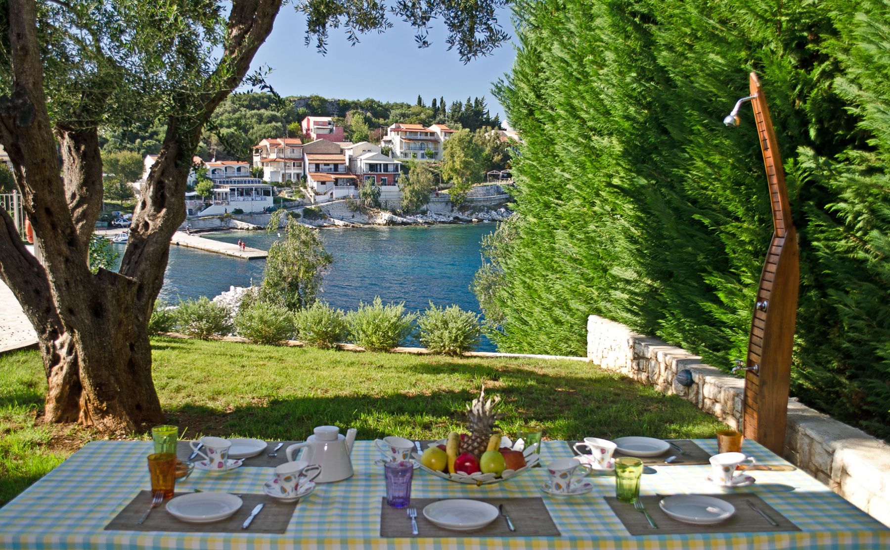 Garden with dining table and view of Kassiopi at Villa Petra, Corfu