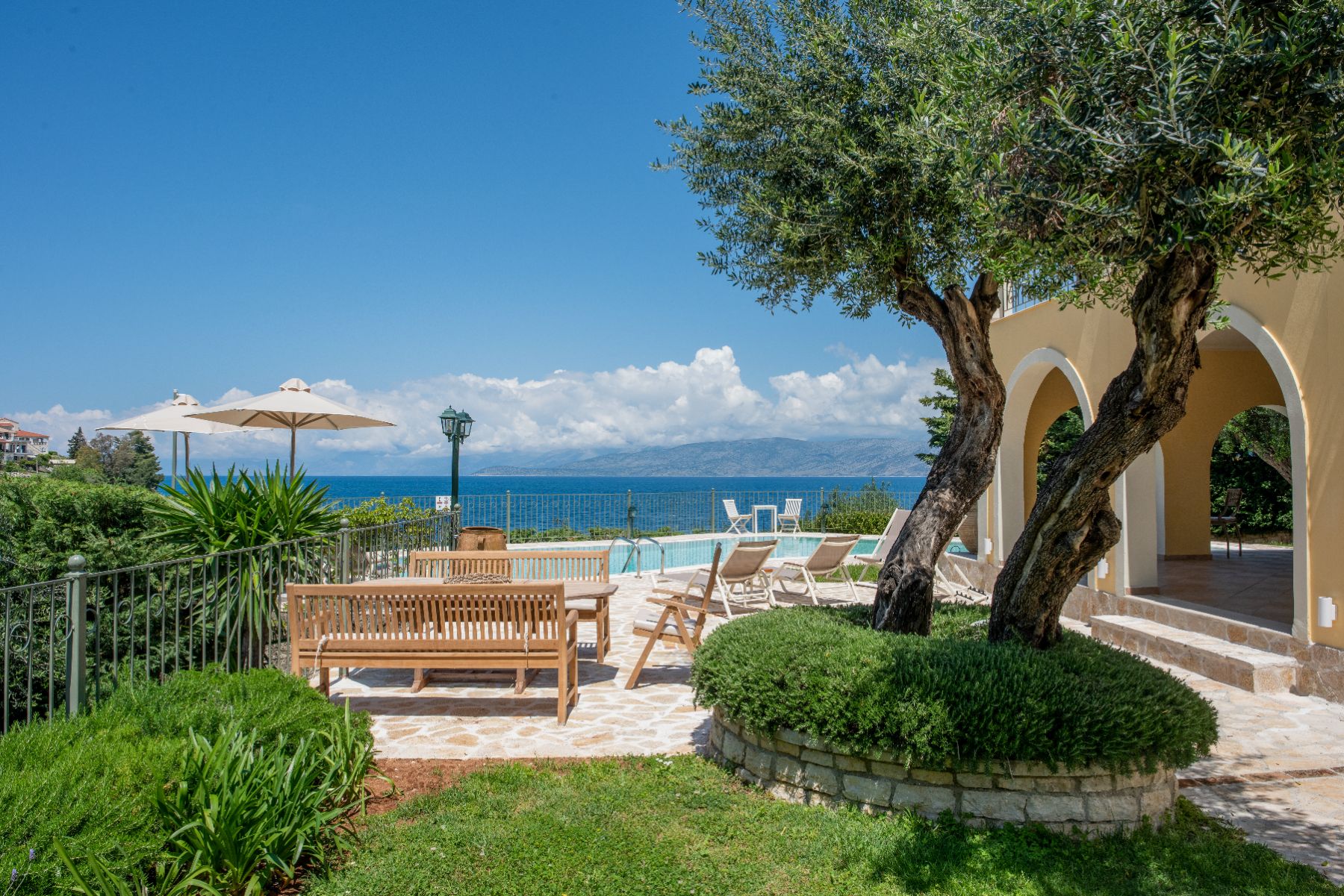 Garden with seating and sea view at Villa Petra, Corfu