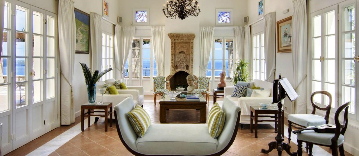 Seating area with occasional furniture, white sofas and green cushions with views over the sea at Villa Selene in Crete