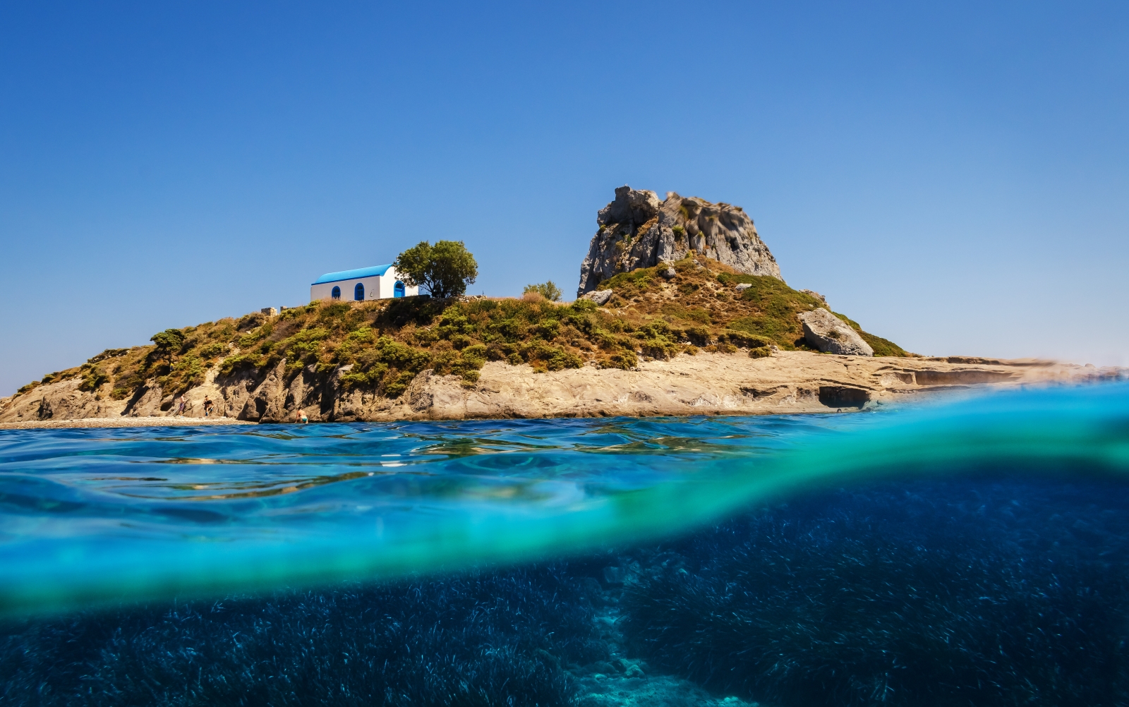 Half underwater shot of an island with a small chapel.